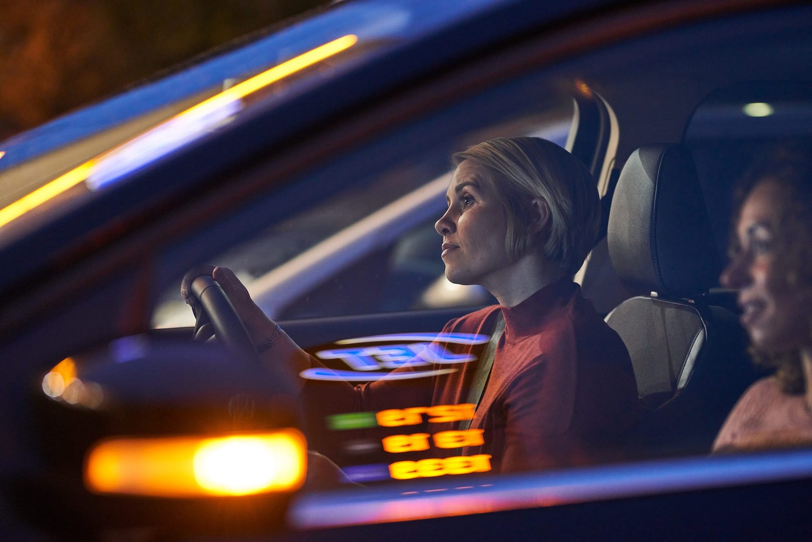 Woman sat in passenger seat of a car.